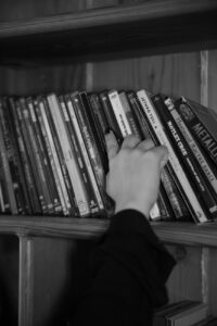 a person reaching for a book on a shelf